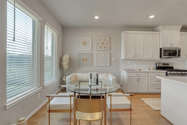 dining area featuring light wood-type flooring, baseboards, and recessed lighting