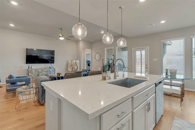 kitchen featuring open floor plan, a sink, and a center island with sink