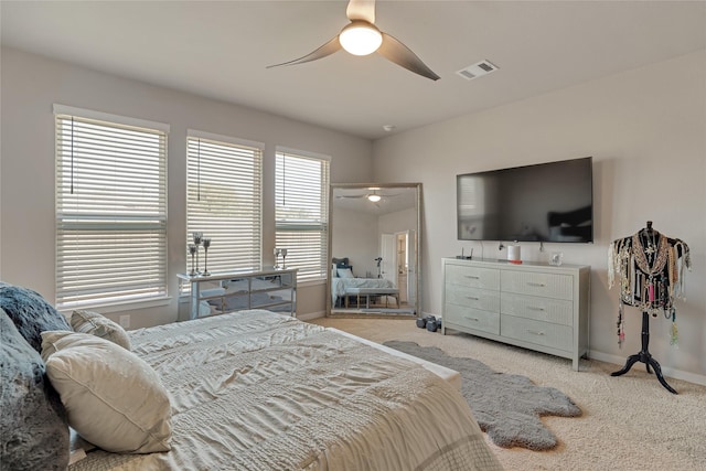 bedroom with a ceiling fan, visible vents, light carpet, and baseboards