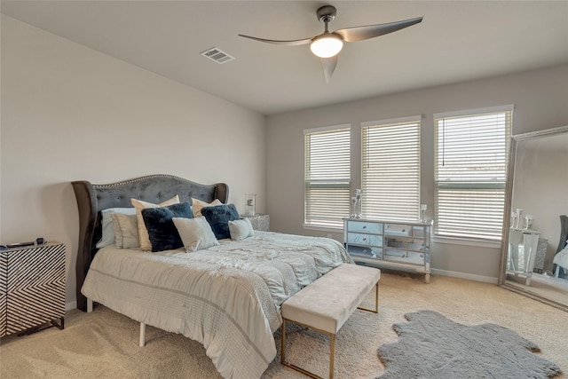 bedroom featuring light colored carpet, visible vents, baseboards, and multiple windows