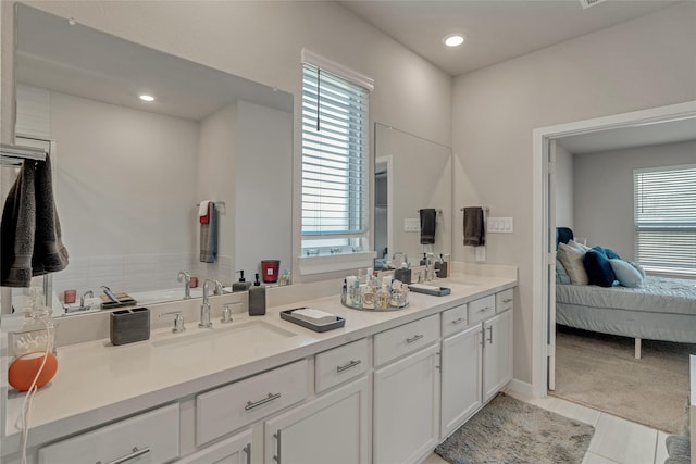 ensuite bathroom with a healthy amount of sunlight, a sink, ensuite bath, and double vanity