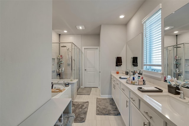 full bath featuring double vanity, a stall shower, and a sink