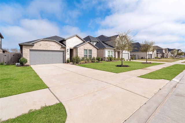 view of front of property featuring a garage, driveway, a residential view, fence, and a front lawn