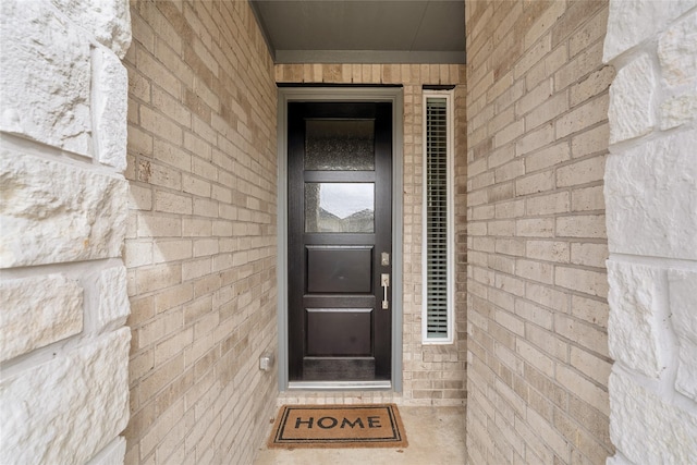 property entrance featuring brick siding