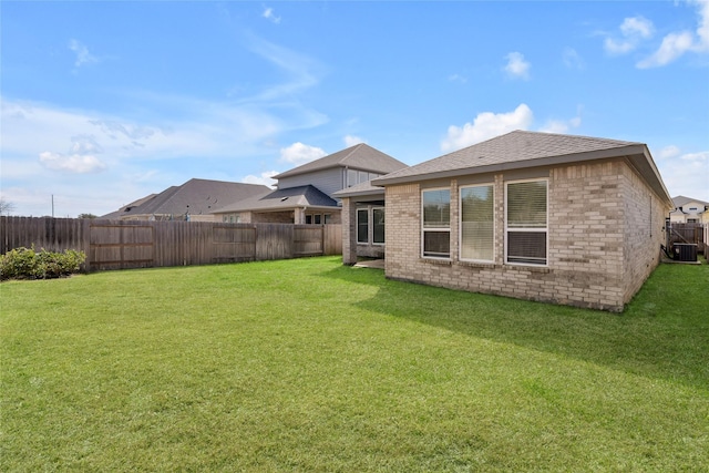 back of property with a yard, brick siding, cooling unit, and a fenced backyard