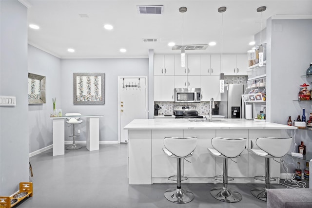 kitchen featuring stainless steel appliances, white cabinetry, visible vents, and decorative light fixtures