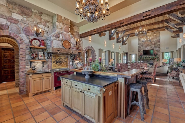 kitchen with arched walkways, dark countertops, open floor plan, an inviting chandelier, and cream cabinetry