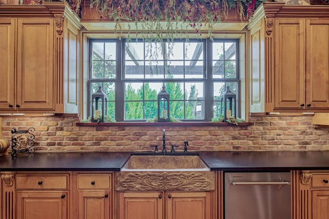 kitchen featuring dishwasher, dark countertops, and a sink