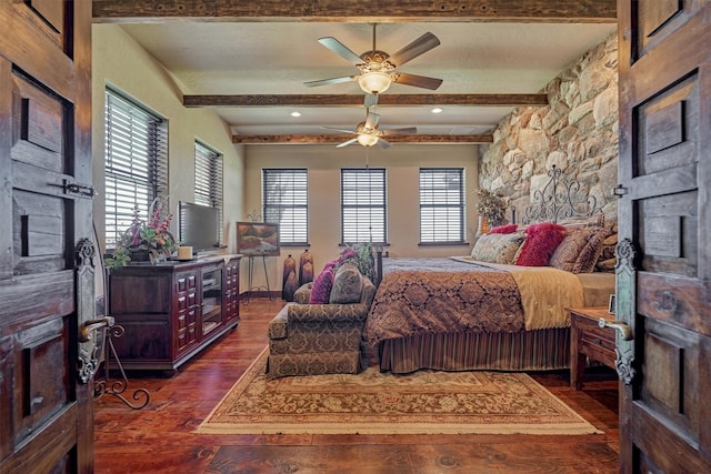 bedroom featuring dark wood-style flooring, baseboards, a fireplace, and beamed ceiling