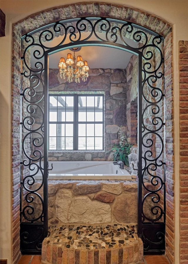 bathroom with a chandelier and a garden tub