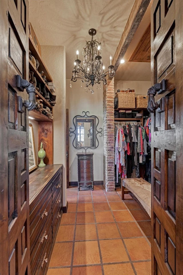 walk in closet with an inviting chandelier