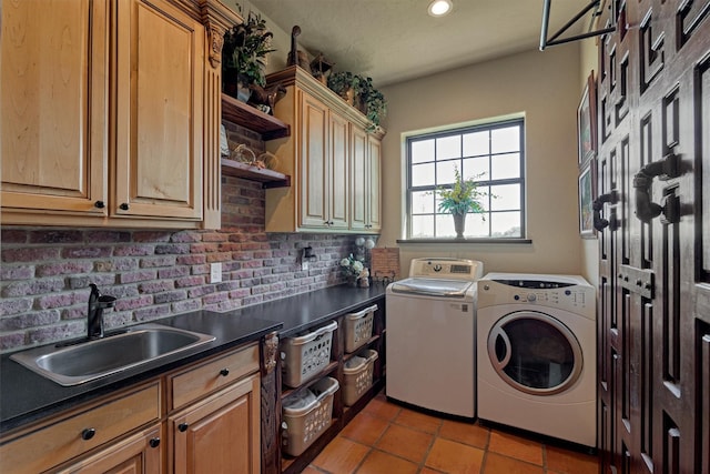 laundry area featuring washing machine and dryer, cabinet space, a sink, and recessed lighting