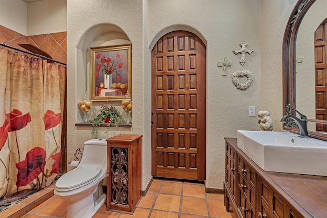 full bath with a textured wall, vanity, toilet, and a shower with curtain