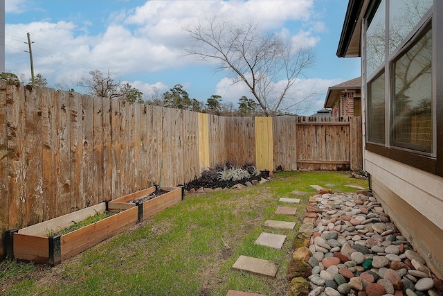 view of yard featuring a garden and a fenced backyard