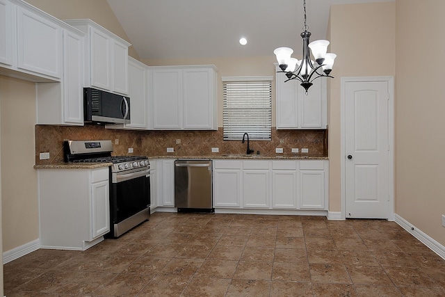 kitchen with stainless steel appliances, a sink, white cabinetry, dark stone counters, and tasteful backsplash