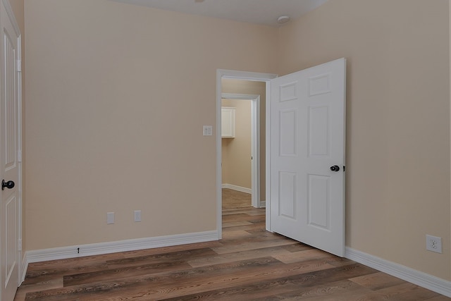 unfurnished room featuring wood finished floors and baseboards