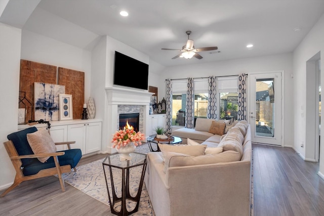 living area with light wood-style floors, recessed lighting, a fireplace, and baseboards