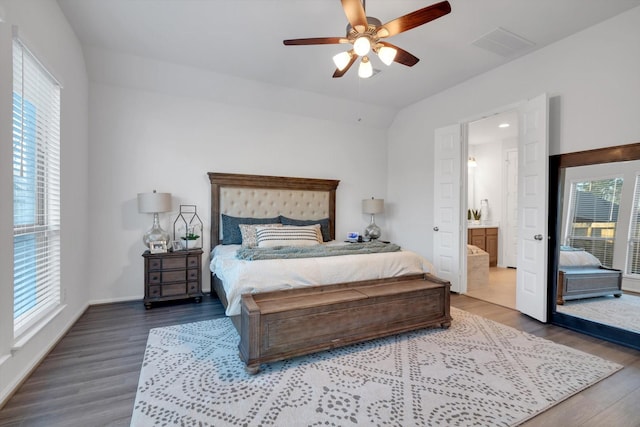 bedroom featuring multiple windows, wood finished floors, visible vents, and baseboards