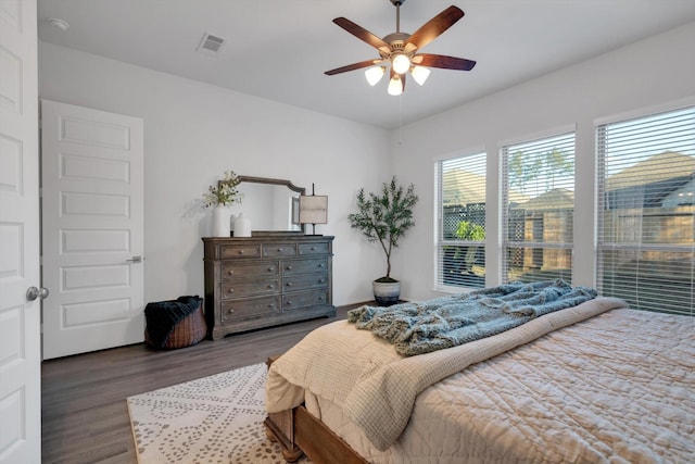 bedroom featuring dark wood-style floors, ceiling fan, and visible vents