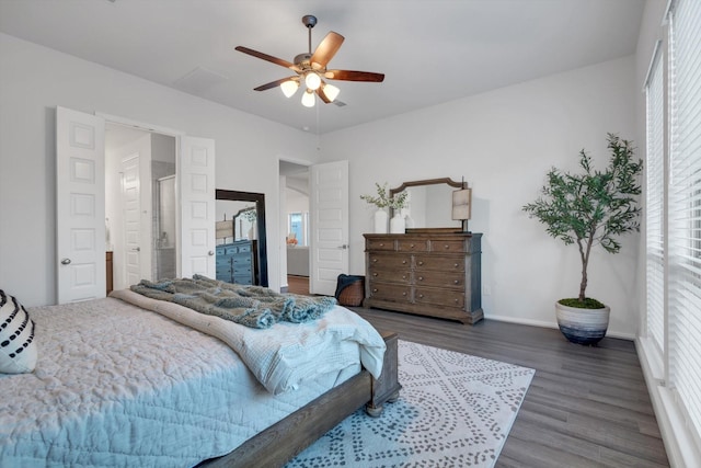 bedroom with dark wood-style floors, ceiling fan, visible vents, and baseboards