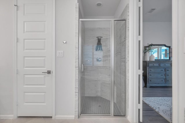 bathroom with a shower stall, visible vents, and baseboards