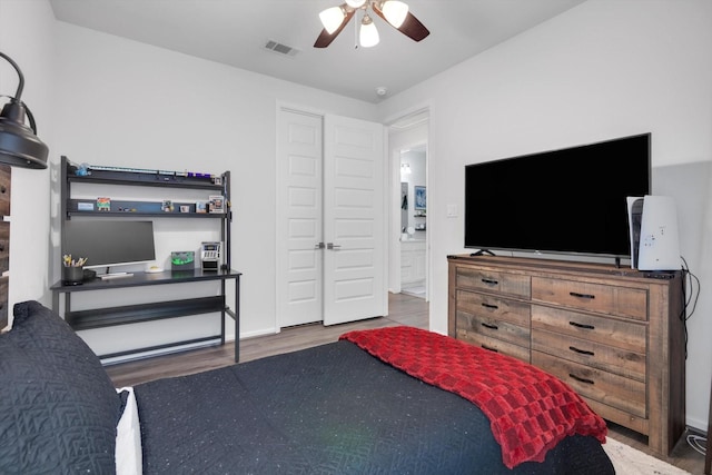 bedroom with wood finished floors, visible vents, and a ceiling fan