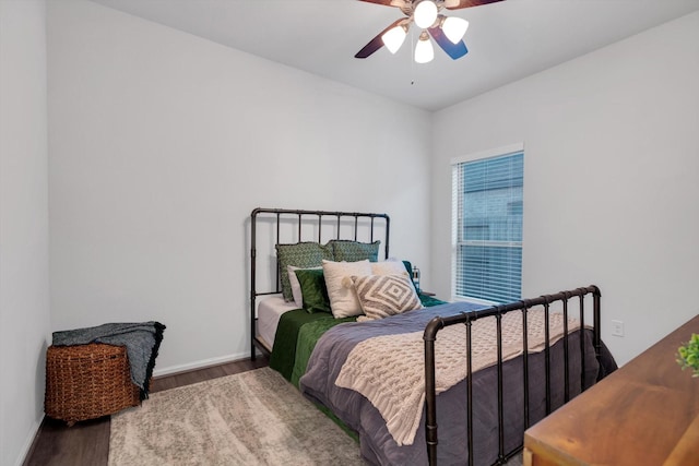 bedroom featuring wood finished floors, a ceiling fan, and baseboards