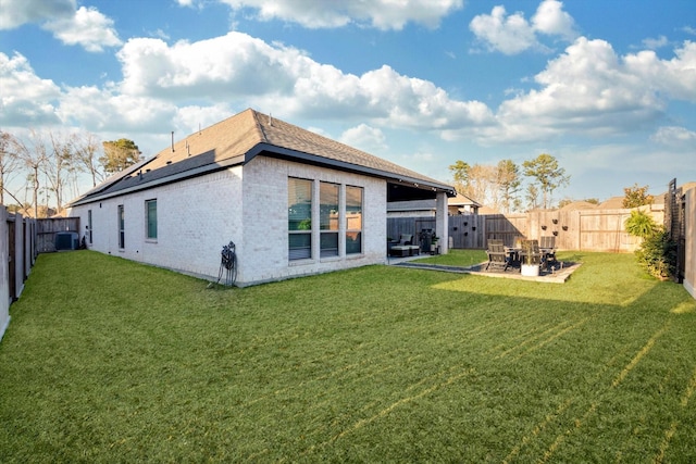 rear view of house with a patio area, a fenced backyard, central AC unit, and a yard