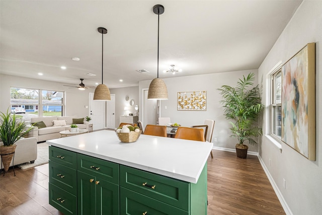 kitchen with a kitchen island, pendant lighting, light countertops, and green cabinetry