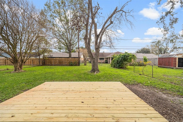 wooden terrace with a fenced backyard and a lawn