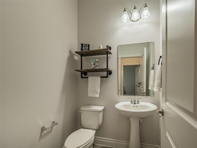 half bathroom with toilet and baseboards