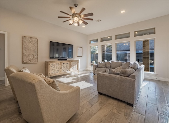 living area with visible vents, light wood-style flooring, a ceiling fan, recessed lighting, and baseboards