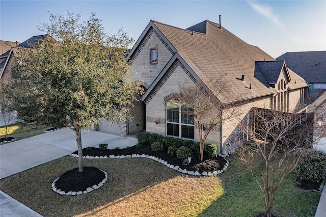 french country inspired facade featuring stone siding, concrete driveway, a front lawn, and a shingled roof