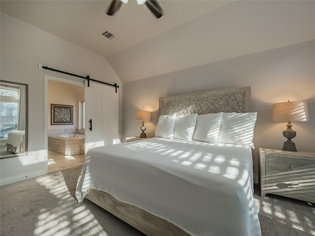 carpeted bedroom with visible vents, lofted ceiling, ceiling fan, a barn door, and connected bathroom