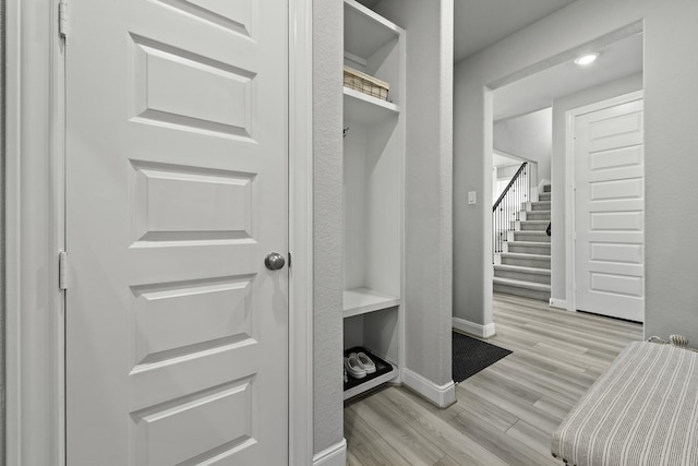 mudroom featuring light wood-style flooring and baseboards