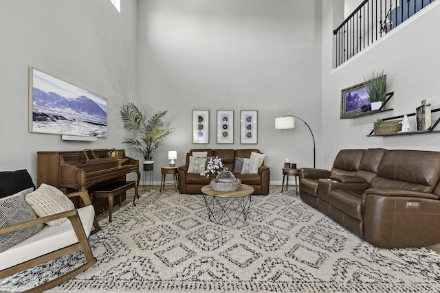 living area featuring a high ceiling and baseboards