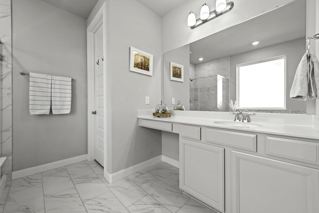 full bath featuring marble finish floor, a marble finish shower, vanity, and baseboards