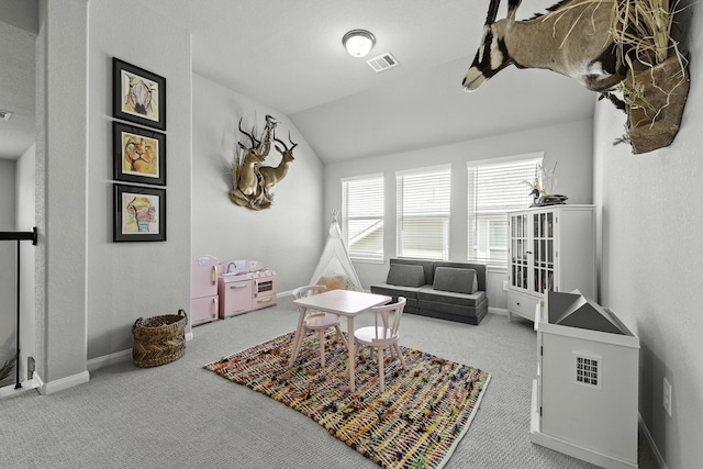 game room featuring baseboards, visible vents, vaulted ceiling, and light colored carpet