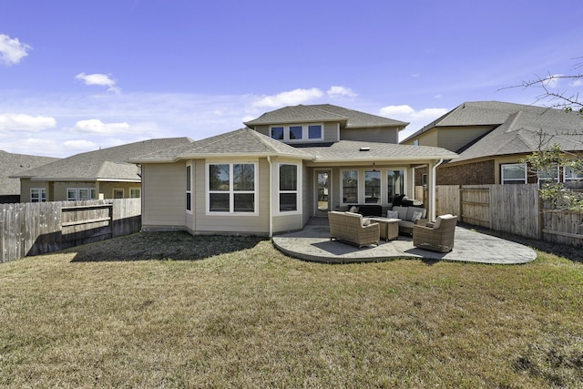 back of house featuring a shingled roof, a patio, a fenced backyard, a yard, and an outdoor living space