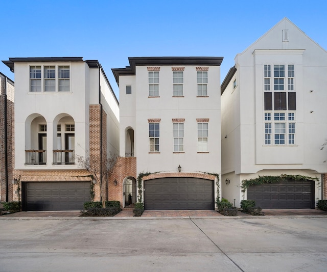 view of front of property featuring a garage, decorative driveway, and stucco siding