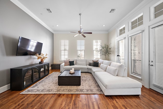 living room featuring ornamental molding, visible vents, and wood finished floors