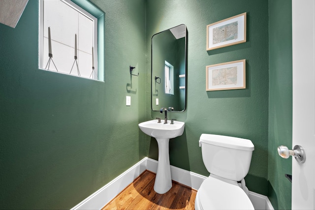 bathroom featuring wood finished floors, toilet, and baseboards