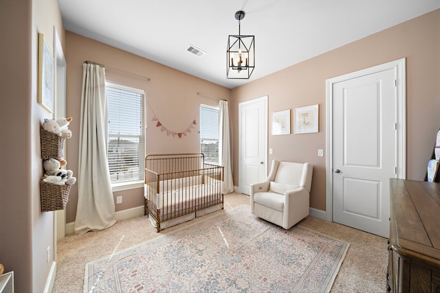 bedroom featuring a closet, visible vents, a chandelier, a nursery area, and baseboards