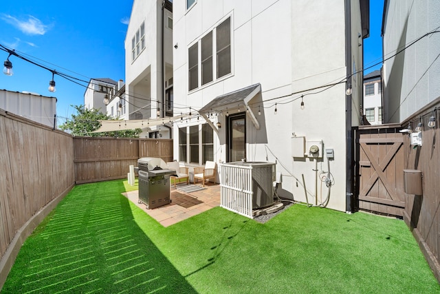 back of property with a yard, a patio area, a fenced backyard, and stucco siding