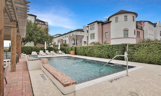 community pool with a residential view and a patio