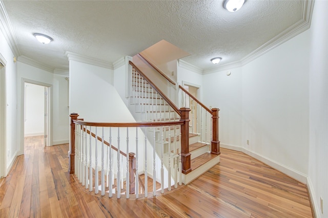 stairs featuring ornamental molding, wood-type flooring, and baseboards