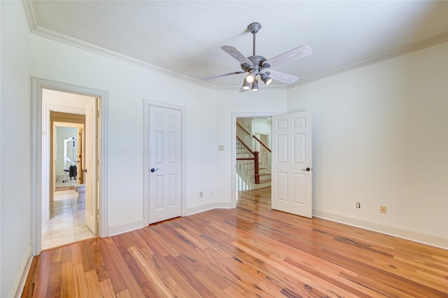 122 Vieux Carre Dr, Houston, TX 77009 - empty room featuring ornamental molding, light wood-style floors, ceiling fan, baseboards, and a textured ceiling
