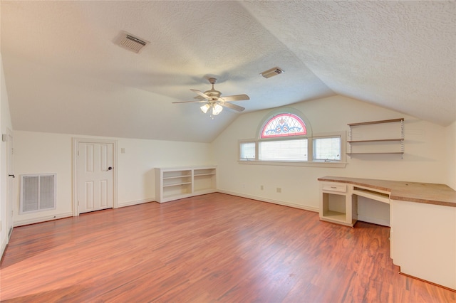 additional living space featuring lofted ceiling, wood finished floors, and visible vents