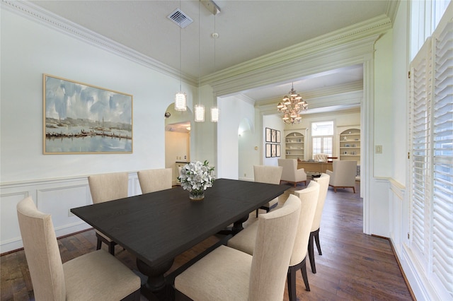 dining area with a wainscoted wall, wood finished floors, visible vents, and crown molding