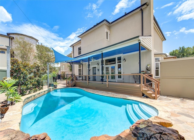 view of pool featuring a wooden deck, a fenced in pool, fence, french doors, and a patio area